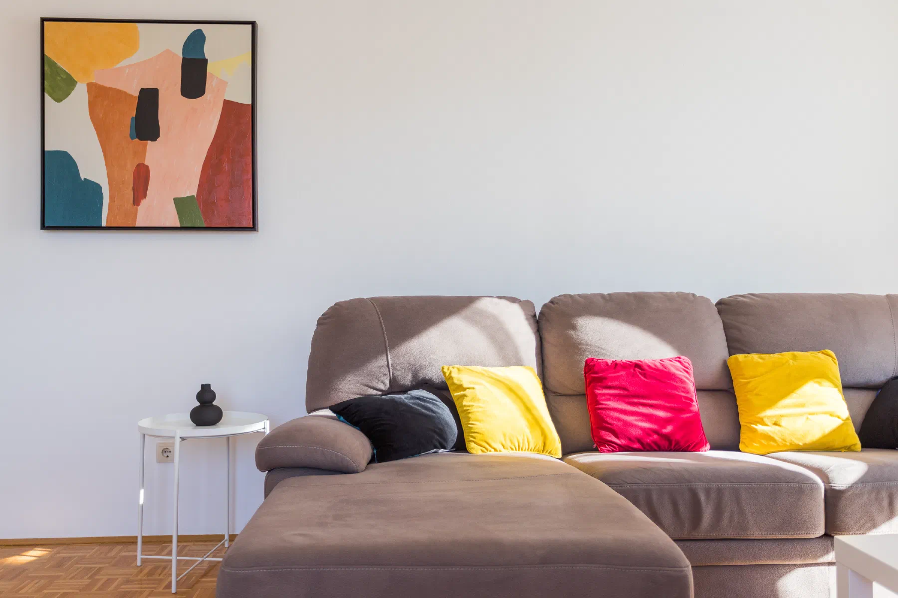 A sunlit living room with a sofa in warm, natural tones